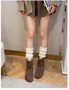 Detailaufnahme brauner Wildleder-Stiefeletten mit weißen Strickschuhen für den Herbst