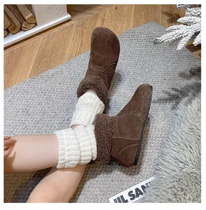 Detail von dunkelbraunen Wildleder-Stiefeletten mit Lammfellbesatz und Strickstulpen