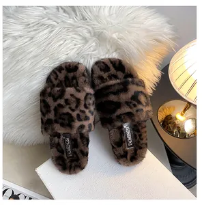 Detailed view of leopard print faux fur slippers on a white display box and plush rug