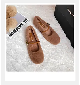 Detail van pluizige bruine Mary Jane flats met bandje en gouden metalen gesp
