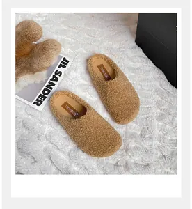 Close-up of tan shearling Boston clogs featuring a soft faux fur texture and branded insole