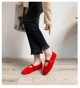Ballerines Mary Jane en velours rouge avec bride à boucle portées avec un pantalon noir