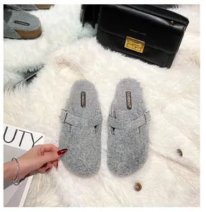 Detail von grauen Plüsch-Birkenstock-Clogs mit Metallschnalle auf gemütlichem Teppich