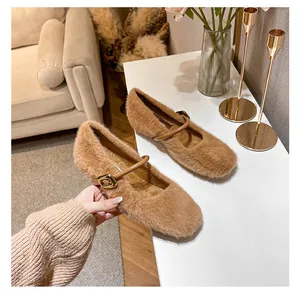 Detail van bruine Mary Jane schoenen van imitatiebont met glanzende gouden gesp