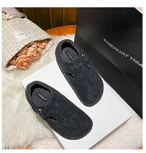 Close-up of charcoal grey felt clog shoes with adjustable buckle and cozy texture