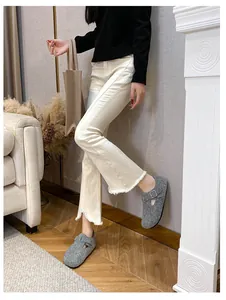 Detail of grey felt Boston clogs with metal buckle worn by a model in casual home setting