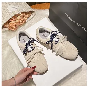 Close-up of beige suede sneakers with dual-textured laces and interior TAOMEN branding