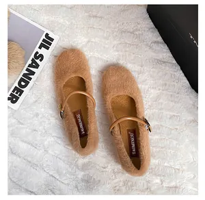 Detailweergave van bruine Mary Jane-schoenen van imitatiebont met gespbandjes op tapijt