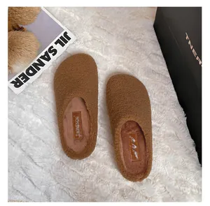 Detailed top view of brown faux shearling mule slippers with warm plush texture