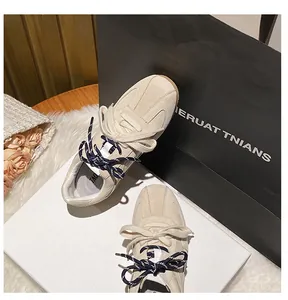 Close-up of beige suede retro sneakers featuring unique double laces and gum rubber soles