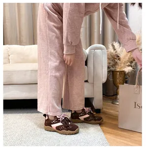 Dettaglio di sneakers platform in pelle rosa e marrone con lacci in un ambiente accogliente