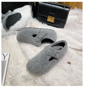 Detail view of gray felt mule slippers with warm plush lining and metallic buckle