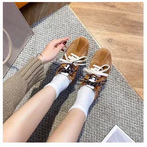 Detail of brown suede casual sneakers with dual-color laces on a stylish carpet