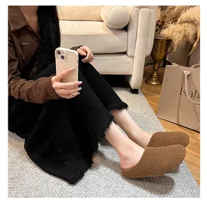 Close-up of brown fuzzy fleece mule slippers with black anti-slip rubber soles for women