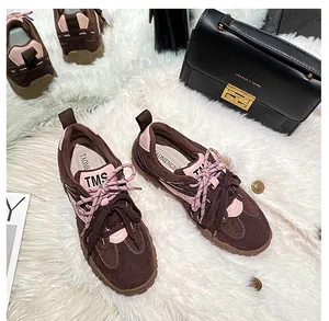 Vista dall'alto dei dettagli delle sneaker in pelle scamosciata marrone con accenti rosa