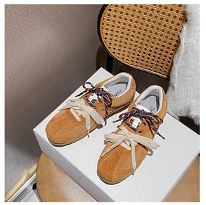 Close-up of brown suede retro sneakers featuring unique double laces and side stripe detail