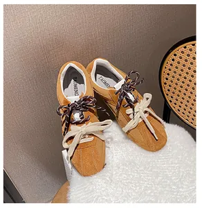 Close-up of brown suede sneakers with a unique double lacing system and TAOMENG logo
