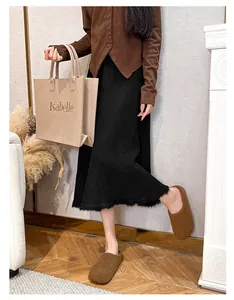 Brown fuzzy mules with knitted cardigan and fringed skirt in a cozy indoor setting