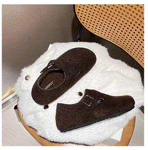 Detail of dark brown felt Birkenstock-style clogs with warm fleece lining and buckle