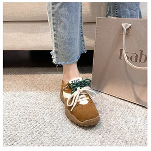 Dettaglio di sneakers in camoscio marrone con zeppa e doppio sistema di allacciatura