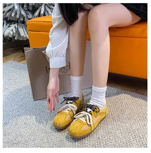 Detailed top view of yellow suede sneakers with unique double laces on model feet