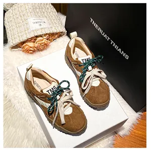 Dettaglio di sneaker in pelle scamosciata marrone con plateau e lacci bicolore retrò