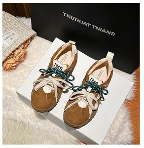 Dettaglio di sneaker in pelle scamosciata marrone con doppi lacci e punta rotonda