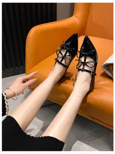 Close-up of black patent leather pointed flats with elegant multi-bow strap detailing