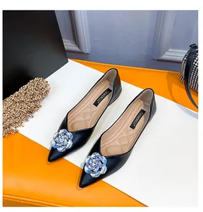 Close-up of black pointed flat shoes featuring luxury rhinestone flower and quilted insole