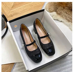 Detalle de zapato Mary Jane de lentejuelas negras con hebilla de perla y punta acharolada