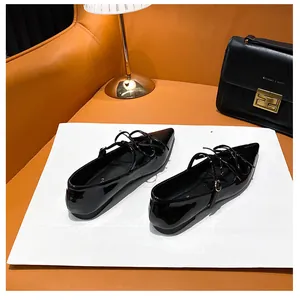 Close-up of elegant black pointed-toe Mary Jane flats with glossy patent leather finish