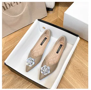 Macro detail of pointed toe flat shoe with sparkling rhinestone flower and quilted insole