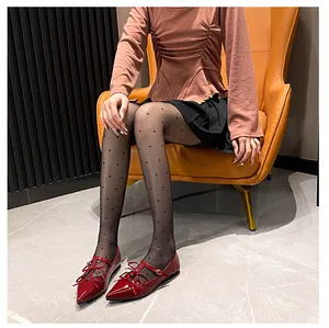 Macro shot of red glossy pointed-toe Mary Janes with delicate bow straps for women