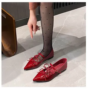 Detail of red pointed-toe Mary Jane flats with double bow and glossy patent finish