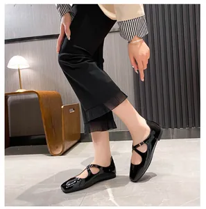 Close-up of black patent leather Mary Jane flats with cross straps and square toe design