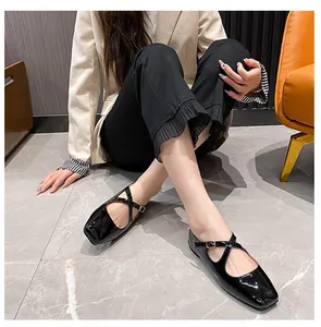 Detailed view of black patent leather Mary Jane shoes with square toe and cross straps
