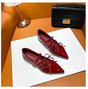 Macro shot of red patent leather pointed toe Mary Jane flats with layered bow strap detail