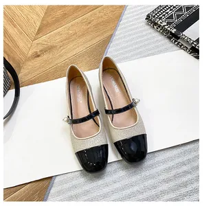 Detalle de zapatos Mary Jane de purpurina con puntera de charol negro y perla fina