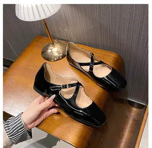 Close-up of black patent leather Mary Jane shoes with cross straps and square toe detail