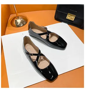 Detail of black patent leather Mary Jane flats with square toe and cross straps
