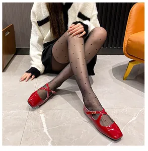 Detailed view of red patent leather Mary Jane flats with cross straps and metal buckle
