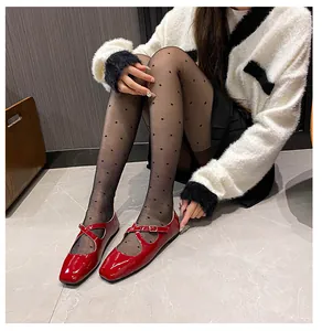 Detail of red patent leather Mary Jane shoes with square toe and cross straps on feet