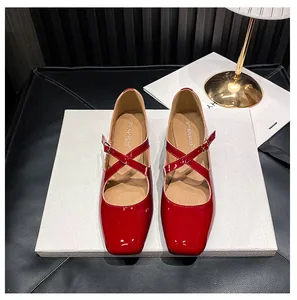 Macro view of red patent leather Mary Jane flats with square toe and cross buckle detail