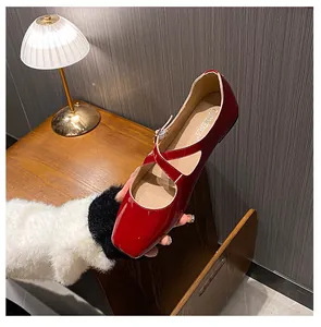Close-up of wine red patent leather Mary Jane shoes with crisscross straps and square toe
