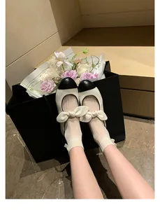 Chic black and white leather Mary Janes with bow detail on a marble floor