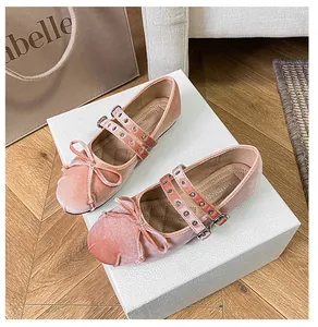 Details der rosa Samt-Mary-Jane-Schuhe mit Doppelriemen und dekorativen Schleifen