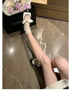 Top view of two-tone Mary Jane flats featuring a beige body and black patent leather toe