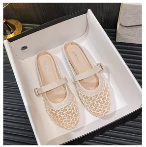 Close-up of beige mesh Mary Jane flats with glossy patent leather and buckle strap detail