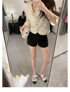 Mirror selfie showing bow-accented Mary Jane flats paired with a knit cardigan and shorts