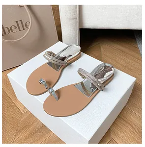 Detail of silver heel insert and rhinestone straps on women's flat toe-loop sandals
